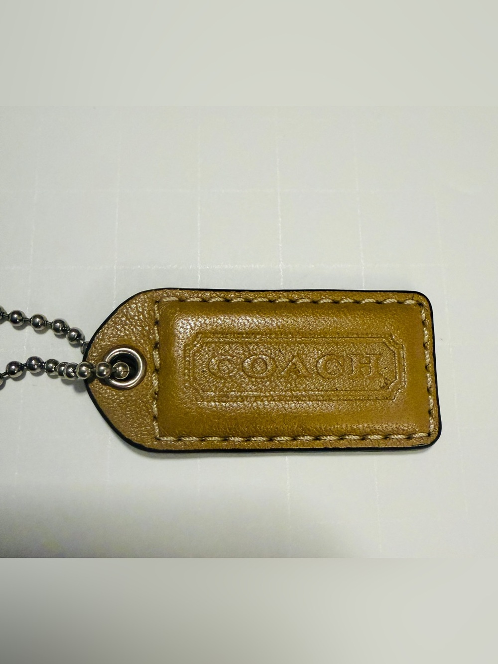 Coach Tan Leather Hang Tag with Silver Ball chain.